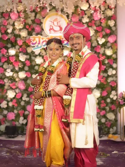 A full-length shot of the couple, highlighting the beautiful drape of the bride's Nauvari and the groom's traditional kurta.
