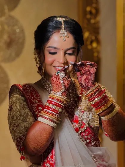 A candid moment showing the bride adjusting her nath. The soft glam makeup ensures she looks perfect from every angle.