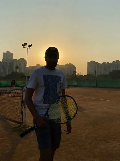 Facing the court, racket in hand. I am committed to helping every student find their own passion for tennis and reach their full potential.