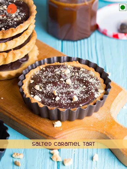 A delicious Salted Caramel Tart. This treat has a crisp pastry shell filled with a rich, gooey salted caramel and chocolate filling.