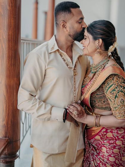 A tender moment captured between a husband and wife. Her traditional bridal saree and his custom silk shirt were both designed by us to celebrate their journey together.