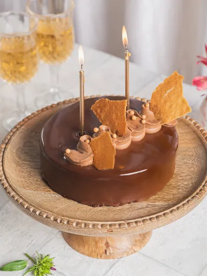 Our Hazelnut Praline cake, decorated with candles and ready for a New Year's or birthday celebration.