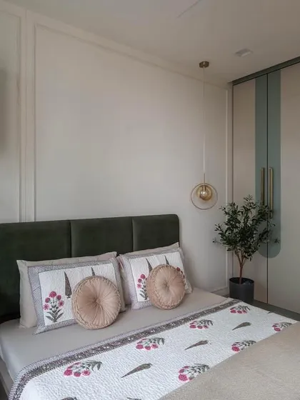 A beautiful transformation. This once-bare room is now a serene guest bedroom, featuring a soothing color palette of sage green and olive, with custom-designed wardrobes and a cozy study nook.