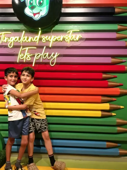 Two brothers share a hug in front of our colorful pencil wall, a perfect picture spot.