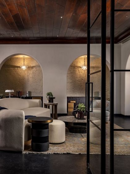 Arched nooks and soft, curved furniture create intimate seating areas within the larger basement lounge. This design strategy allows the expansive space to feel welcoming and comfortable, whether hosting a few guests or a large crowd.