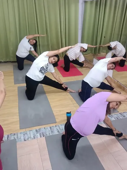 A moment from one of my power yoga classes, with students in Parighasana (Gate Pose). This pose provides a deep side-body stretch, improving flexibility in the spine and hamstrings.