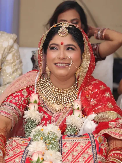A candid moment during the wedding ceremony. The bride's smile is radiant, and her makeup looks flawless even in the midst of the celebration.
