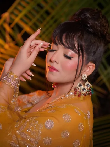 Eyes closed to showcase the vibrant, blended eyeshadow. This look is perfect for a bride who wants to make a statement.