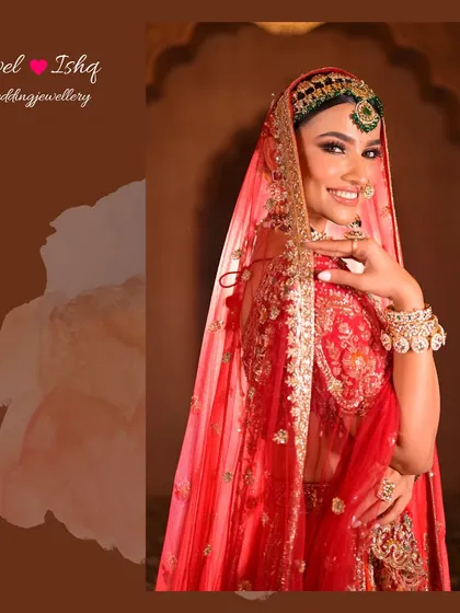 A smiling bride feeling radiant in her complete wedding day look. The layered green beaded jewellery adds depth and color against the red lehenga.