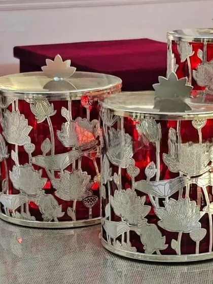 I love the contrast in this piece. These jars feature a silver-plated lotus cutout design over a rich red glass, creating a vibrant and luxurious look.