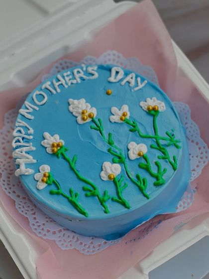 This cheerful blue bento cake for Mother's Day is decorated with hand-piped daisies. It's a little piece of edible art to brighten her day.