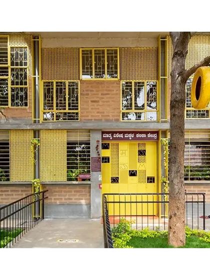 The vibrant yellow facade of the Mathru Centre is a collage of reclaimed windows. What was considered waste from one project became a central design feature for another, demonstrating our approach to resource sharing across sites.