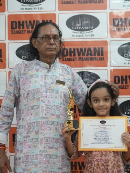 A senior guru with a young student and her award.