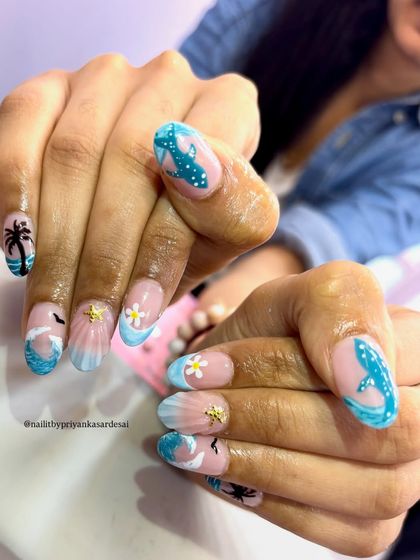 Another angle of the detailed tropical nails, showing off the hand-painted dolphin, starfish charm, and beautiful wave effects.