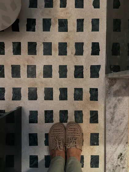 A top-down view of the custom-patterned marble flooring in our studio bathroom. The checkered design using Baroda Green Marble adds a graphic, textural element to the space.