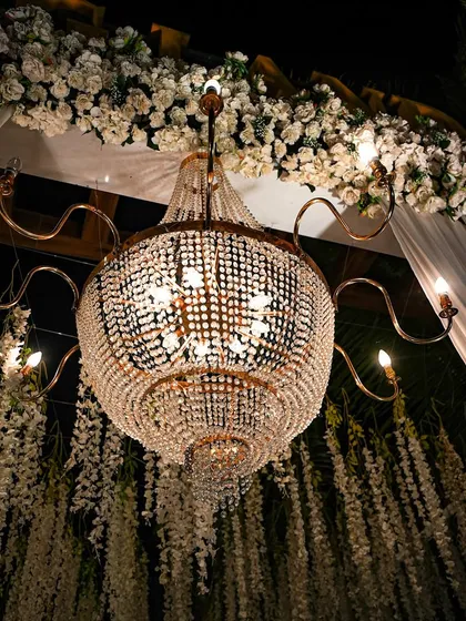 A close-up of a magnificent crystal chandelier. Lighting is key to setting the mood, and these grand chandeliers add a touch of timeless elegance and luxury to any event.