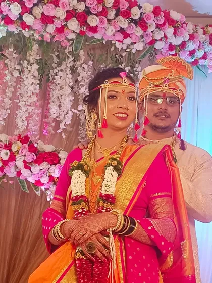 A lovely shot of a Maharashtrian couple during their wedding ceremony. The pink and orange floral decor perfectly complements their traditional attire.