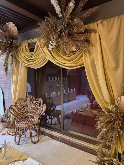 A detail shot of the elegant gold drapery and dried floral arrangements. These elements added a touch of luxury and texture to the boho-themed dinner party.