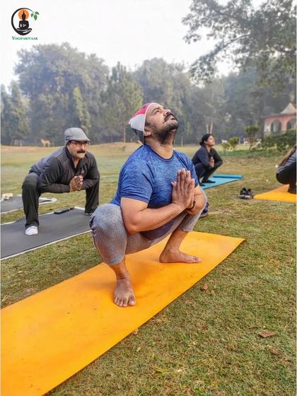 Students practice Malasana (Garland Pose) outdoors, a great squat for opening the hips and strengthening the lower body.
