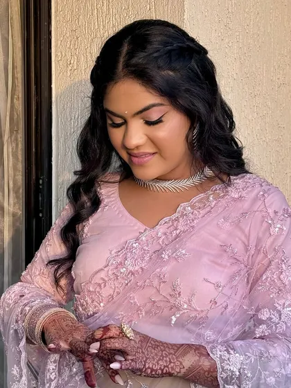 A close-up of the soft pink eye makeup and the elegant braided hairstyle. Every element works in harmony.
