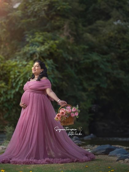 A soft, romantic outdoor portrait in a mauve gown, with the mother-to-be holding a basket of flowers.