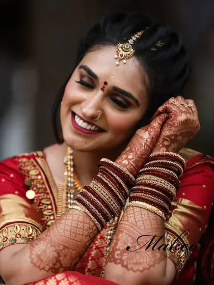 A happy moment from Pooja's varpooje. Her makeup is flawless, with a focus on a bright smile and glowing skin.