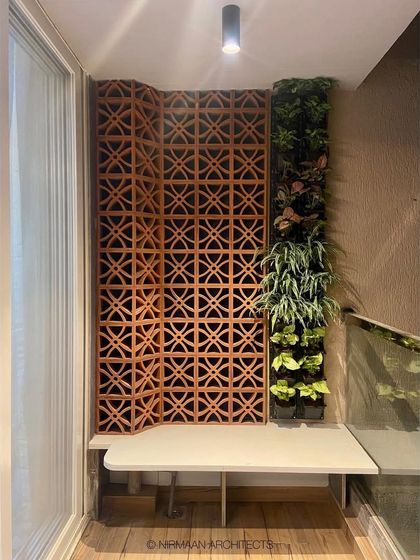 We created this green corner using a terracotta jali screen and a vertical garden. It’s a perfect example of how we bring natural elements and traditional materials into modern homes.