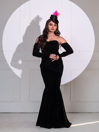 A classic Hollywood-style portrait using a single spotlight. The black mermaid gown and elegant pose create a timeless, cinematic feel, showcasing our versatility in lighting.