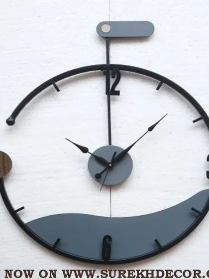 A truly unique designer piece, this wall clock features a semi-circular frame with a wave-like bottom element. The grey and black tones with a touch of chrome create a sleek, contemporary, and artistic timepiece.