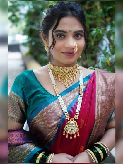 A full portrait of a bride in a classic Paithani saree. The makeup is kept elegant and clean to balance the richness of the saree and the traditional pearl and gold jewelry.