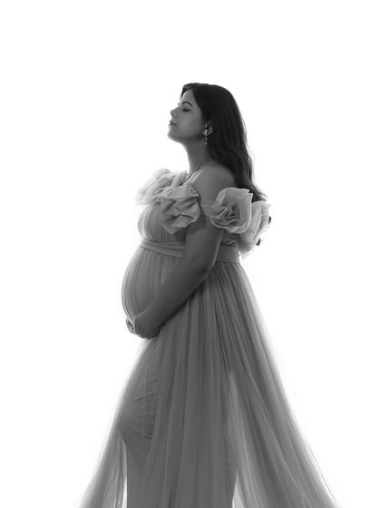 A classic black and white portrait. This high-contrast style emphasizes the silhouette of the Isabella gown and the beautiful emotion of the moment.