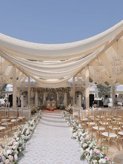 The wedding aisle at the Leela Palace, with its gentle curve and soft fabric draping, created a stunning visual corridor. The design was all about creating a serene and elegant journey for the bride.