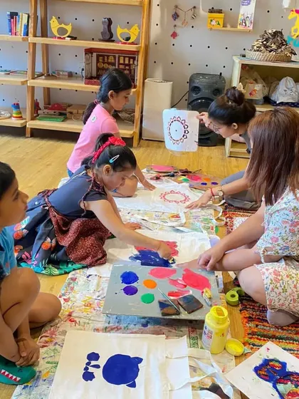 A group of children engrossed in a floor painting session. I provide large spaces and ample materials so that creativity isn't confined to a small canvas.