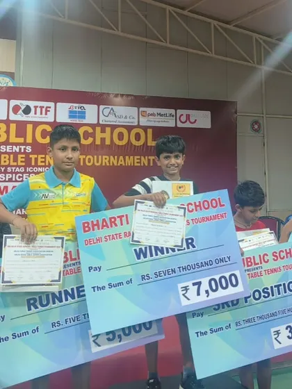 Arunim Agarwal celebrates his victory as the U-13 Boys winner at the Delhi State Ranking Tournament, holding his prize money and certificate.