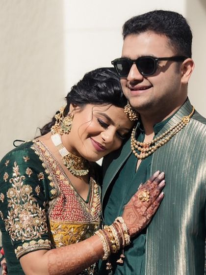 A sweet, intimate moment between the couple during their carnival event. The bride's soft makeup looks beautiful as she rests her head on her groom's shoulder.
