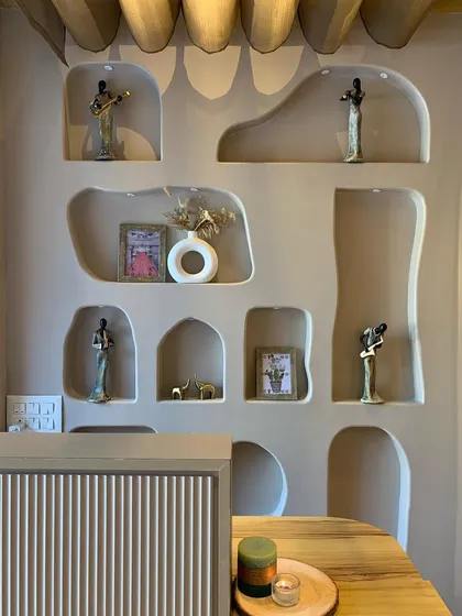 The decor in the studio is designed to create a calm and artistic atmosphere. These unique wall niches hold small art pieces that add to the overall aesthetic.