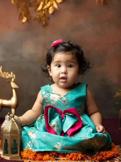 A beautiful portrait from our Indian festive theme, with a baby girl in a lovely teal dress surrounded by traditional decor.
