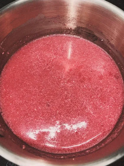 The raspberry mixture cooking gently on the stove. This process requires patience to get the perfect consistency.