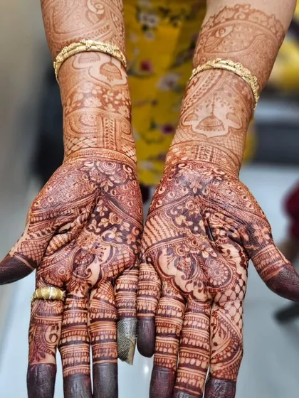 Another look at a gorgeous, mature henna stain. The color is even and dark throughout the design, from the intricate palms to the patterns on the arms.
