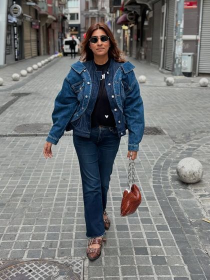 Denim on denim is always a good idea. This look features a classic denim jacket and jeans, elevated with a statement bag and shoes.