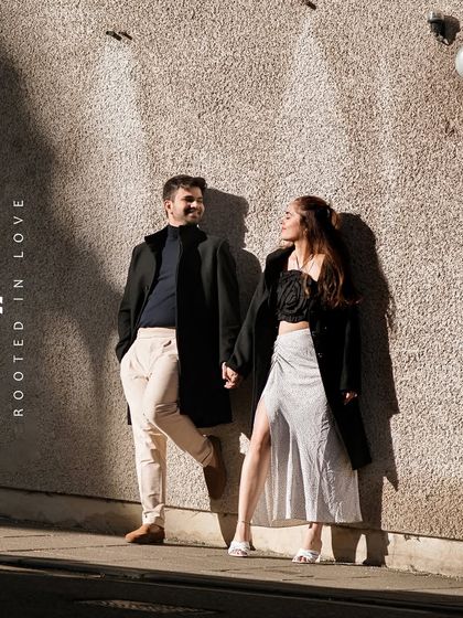 A fashion-inspired shot of the couple against a textured wall with dramatic sunlight and shadows. This image showcases their modern style and our artistic approach to composition.