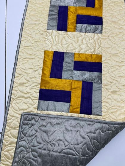 This view shows the reversible nature of the table runner, with a solid grey silk back.