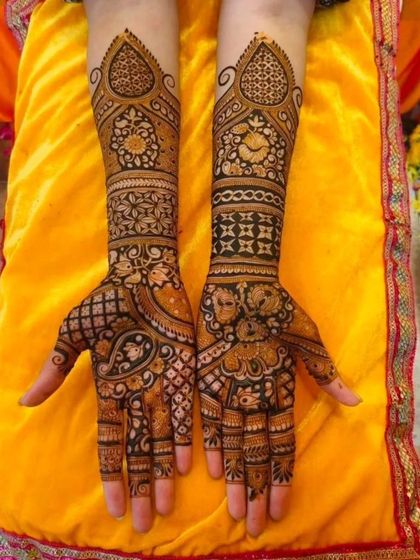 This design showcases a mix of intricate patterns, including jaali (net), floral bands, and paisley motifs. The different textures and styles work together to create a visually interesting full-hand mehendi.