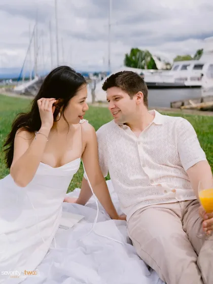 Sharing a glass of juice and a quiet conversation during their lakeside picnic. It’s a simple, happy moment that shows their easy, comfortable love.