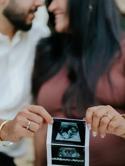 A close-up of the couple holding their baby's first photos. This detailed shot is a powerful part of any pregnancy announcement photo series.