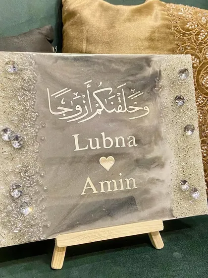 A unique and heartfelt gift for a special couple. This handmade resin plaque features the couple's names and a Quranic verse in a beautiful silver and grey marble design, wishing them a lifetime of love and togetherness.