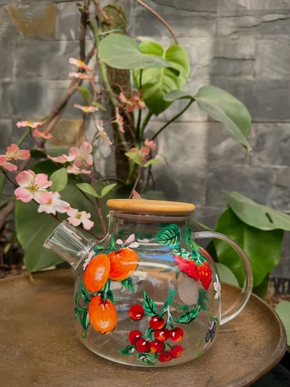 This beautiful glass teapot is painted with a fruity peach and cherry design, perfect for brewing and serving your favorite tea.