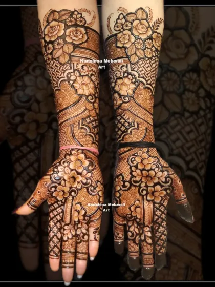 This full-coverage bridal mehendi design extends up to the elbows, perfect for the bride who wants a rich and traditional look. It features bold, shaded roses and other floral motifs, combined with intricate jaali net patterns and classic details on the palms.