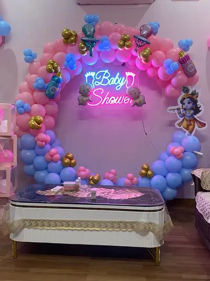 This image provides a complete view of the Kanha ji themed baby shower setup, including the central ring, side pillars, and 'BABY' blocks, all coordinated in pink and blue.