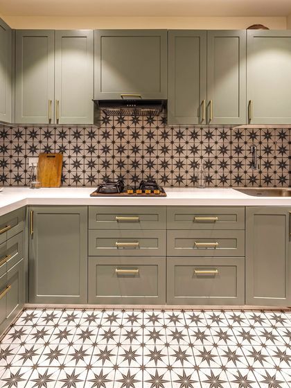 This kitchen combines traditional patterns with modern functionality. We chose sage green for the cabinetry and paired it with patterned tiles for both the floor and backsplash, creating a space that is full of character, warmth, and vintage charm.
